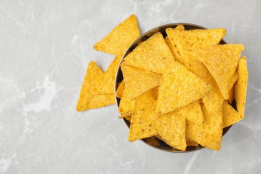 Gri masa üzerinde lezzetli Meksika nachos cips ile Metal kase, düz yatıyordu. Metin için alan
