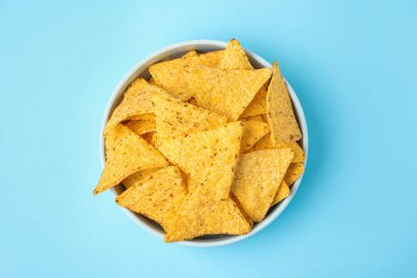 Açık mavi arka plan üzerinde lezzetli Meksika nachos cips ile Bowl, üst görünümü