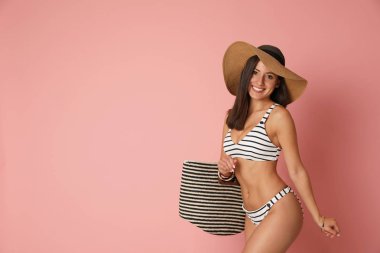 Mercan arka plan üzerinde şık çizgili bikini ince vücut ile Pretty seksi kadın, metin için alan