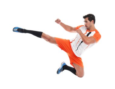 Genç adam beyaz arka planda futbol oynuyor.