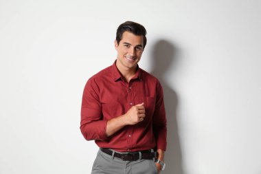 Hafif bej arka plan üzerinde şık giysiler içinde Yakışıklı genç adam