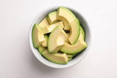 Beyaz masada kesilmiş avokado ile Kase, üst görünümü