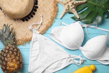 Açık mavi ahşap zemin üzerinde plaj nesneleri ile düz kompozisyon yatıyordu