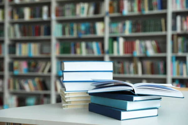 Bunt med böcker på vitt bord i biblioteket — Stockfoto
