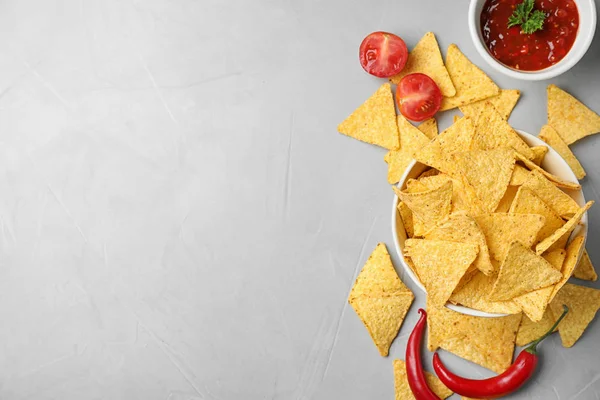 Flat lay composition with tasty Mexican nachos chips on grey table, space for text — Stock Photo, Image