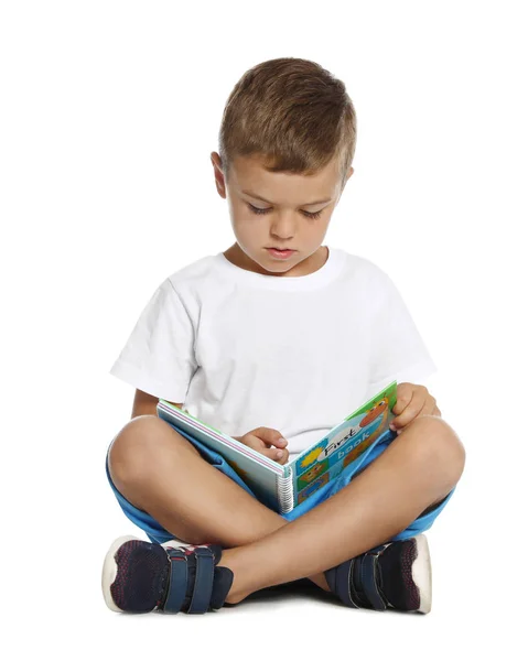 Söt liten pojke läser bok på vit bakgrund — Stockfoto