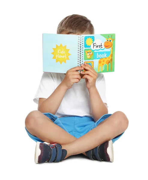 Niedlicher kleiner Junge liest Buch auf weißem Hintergrund — Stockfoto