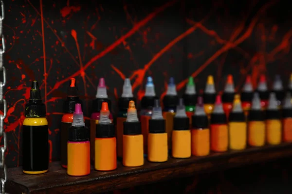 Garrafas de tintas na prateleira no salão de tatuagem — Fotografia de Stock