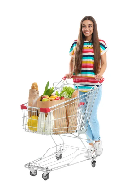 Mujer joven con carrito de compras completo sobre fondo blanco —  Fotos de Stock