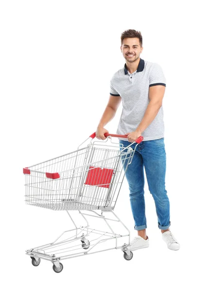 Jovem com carrinho de compras vazio no fundo branco — Fotografia de Stock