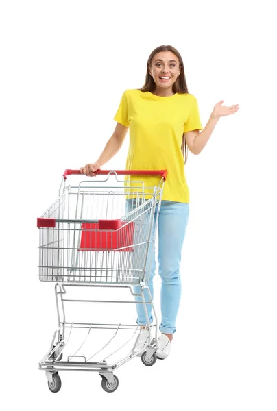 Young woman with empty shopping cart on white background — Stock Photo, Image