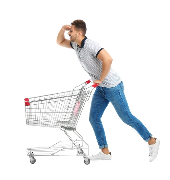 Jovem com carrinho de compras vazio no fundo branco — Fotografia de Stock