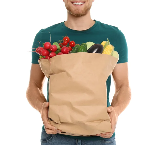 Joven con bolsa de verduras frescas sobre fondo blanco, primer plano — Foto de Stock