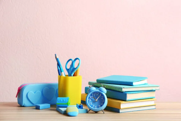 Diferentes artigos de papelaria escolar em mesa de madeira contra fundo rosa — Fotografia de Stock