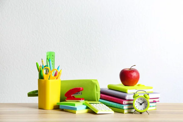 Verschiedene Schulschreibwaren auf Holztisch vor weißem Hintergrund — Stockfoto