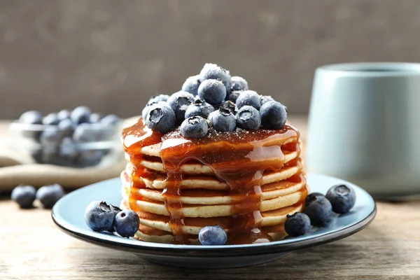 Delicious pancakes with fresh blueberries and syrup on wooden table — Stock Photo, Image