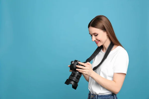 Professionele fotograaf met moderne camera op licht blauwe achtergrond. Ruimte voor tekst — Stockfoto