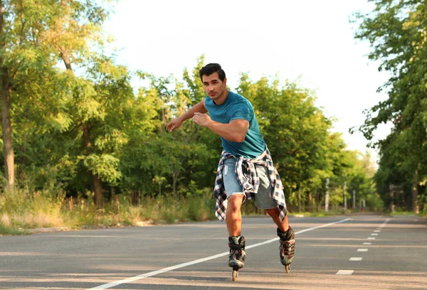 Knappe jonge man roller skating in Park — Stockfoto