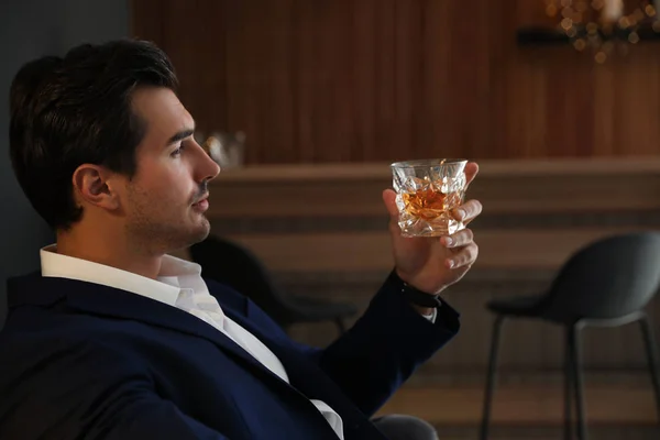 Jeune homme avec un verre de whisky au bar — Photo