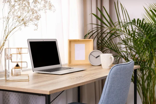 Stilvolles Arbeitsplatzinterieur mit Laptop auf Holztisch neben Fenster — Stockfoto