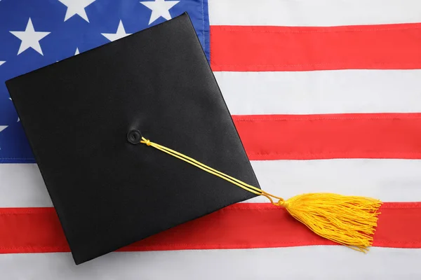 Sombrero de graduación negro en bandera nacional de EE. UU., vista superior — Foto de Stock