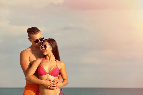 Jovem de biquíni passando tempo com o namorado na praia. Casal encantador — Fotografia de Stock