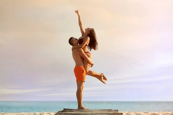 Jovem de biquíni passando tempo com o namorado na praia. Casal encantador — Fotografia de Stock