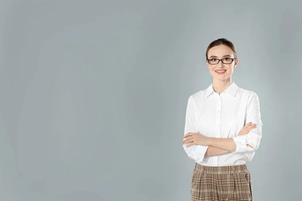 Retrato de una joven profesora sobre fondo gris. Espacio para texto — Foto de Stock