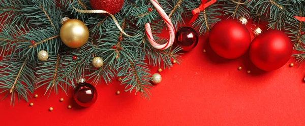 Rami di abete con decorazione natalizia su sfondo rosso, posa piatta. Spazio per testo — Foto Stock