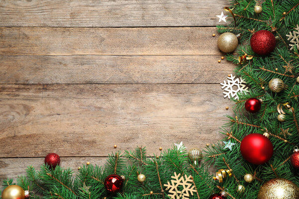 Ветки елки с рождественским декором на деревянном фоне, плоская укладка. Пространство для текста
