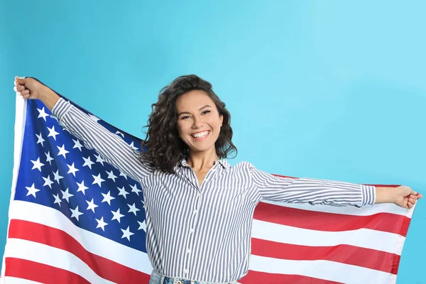 Szczęśliwa młoda kobieta z flagą USA na niebieskim tle — Zdjęcie stockowe