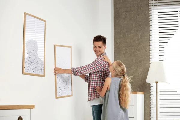 Vader en dochter opknoping foto op muur thuis — Stockfoto