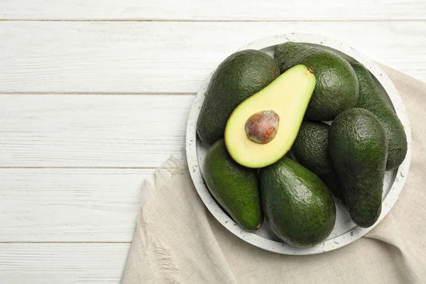 Deliziosi avocado maturi om tavolo in legno bianco, vista dall'alto. Spazio per testo — Foto Stock