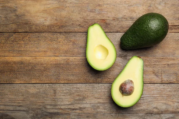 Heerlijke rijpe avocado's op houten tafel, platte lag. Ruimte voor tekst — Stockfoto