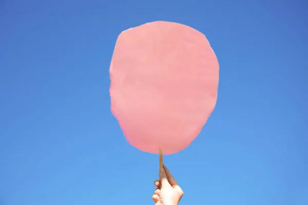 Frau hält weiße Zuckerwatte gegen blauen Himmel — Stockfoto