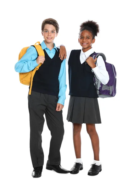 Heureux élèves en uniforme scolaire sur fond blanc — Photo