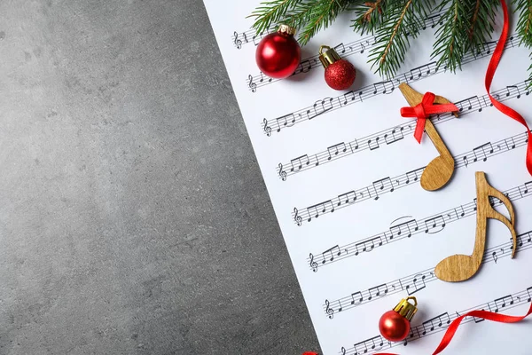 Decoraciones navideñas, notas y hoja de música sobre mesa de piedra gris, plano con espacio para texto —  Fotos de Stock