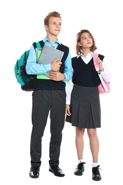 Heureux élèves en uniforme scolaire sur fond blanc — Photo