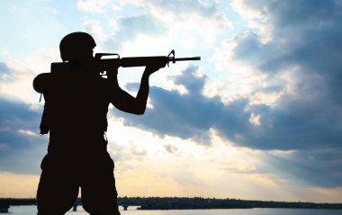 Dışarıda devriye gezen makineli tüfekli bir asker. Askerlik hizmeti