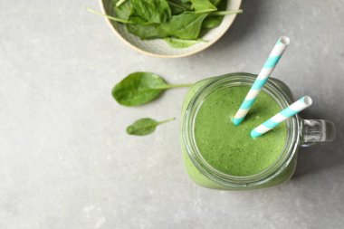 Gri masa üzerinde taze yeşil sağlıklı ıspanak smoothie ile Düz yatıyordu kompozisyon. Metin için alan