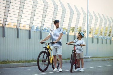 Baba ve oğlu stadyumda bisiklete biniyor