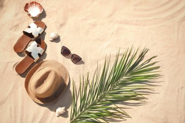 Kum üzerinde şık plaj aksesuarları ile düz döşeme kompozisyon