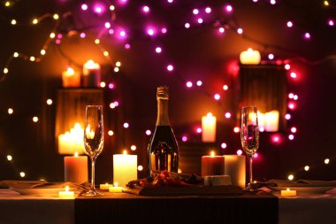 Yanan mumlar ve şenlikLi ışıklar ile romantik yemek masası ayarı