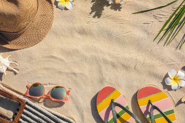 Kum üzerinde farklı plaj aksesuarları ile yapılan çerçeve, üst görünüm. Metin için alan