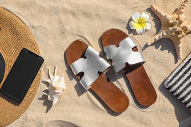 Kum üzerinde farklı plaj aksesuarları ile düz döşeme kompozisyon