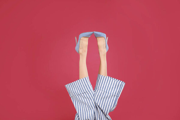 Женщина в элегантной обуви на малиновом фоне
