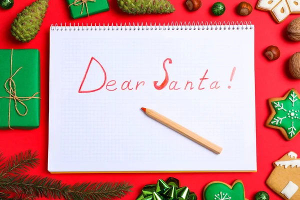 단어 친애하는 산타와 붉은 배경에 크리스마스 장식, 평면 누워 노트북 — 스톡 사진