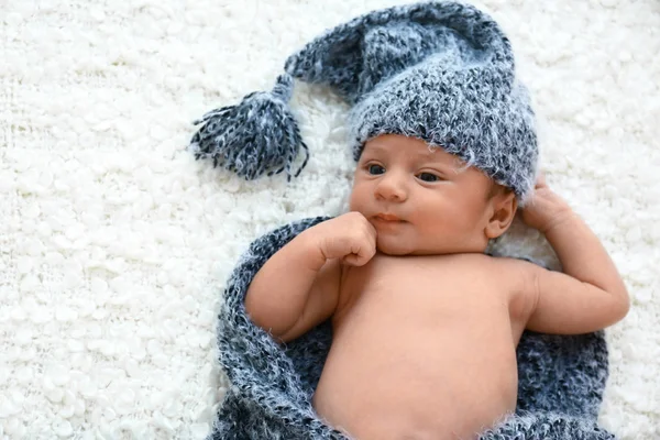 Bebê bonito em chapéu cinza e xadrez deitado em cobertor macio, vista superior. Espaço para texto — Fotografia de Stock