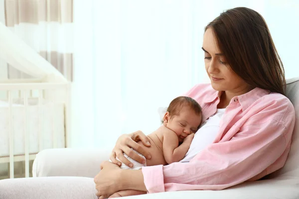 Fiatal anya vele kis baba ül karosszékben otthon. Szóköz a szöveghez — Stock Fotó