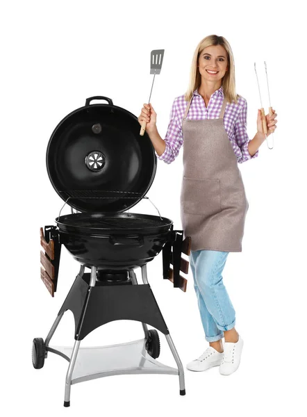 Donna in grembiule con barbecue e utensili su sfondo bianco — Foto Stock
